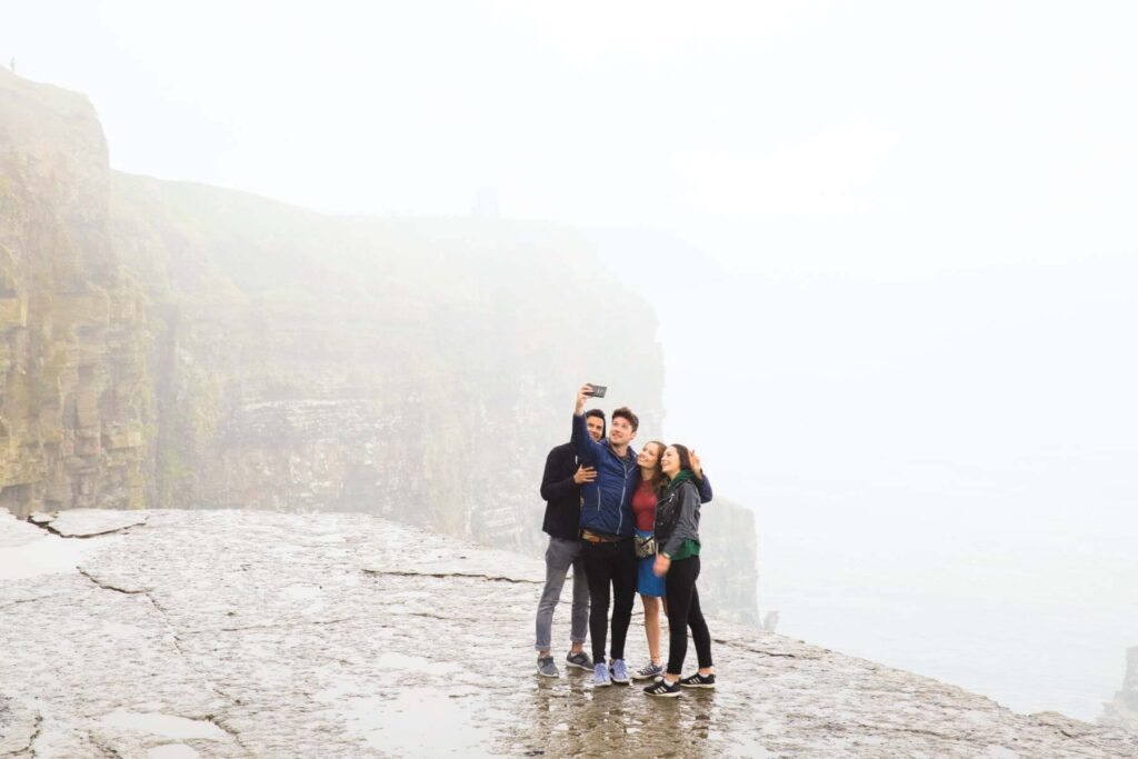 Group-selfie-on-rainy-day-at-the-Cliffs-of-Moher-Co-Clare-©James-Bowden-for-Contiki-and-Tourism-Ireland