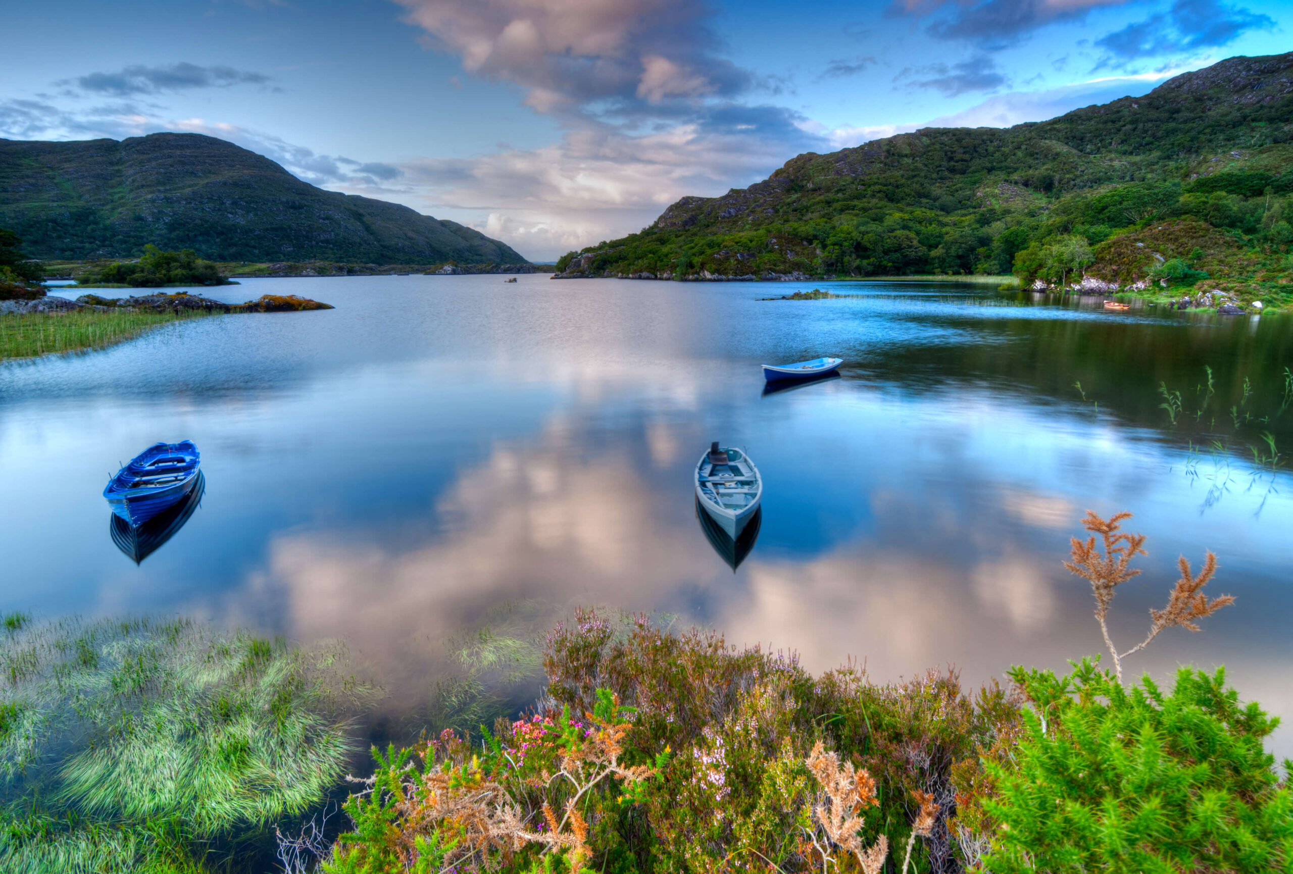 Irish lake with 2 boats and sky reflection, lakeside and waterways holiday homes in Ireland