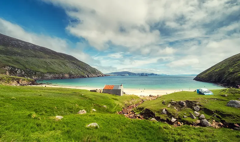 Coastal holiday homes, beautiful ocean view of sunny Keem Bay beach and Cliffs, Achill island, County Mayo, Ireland