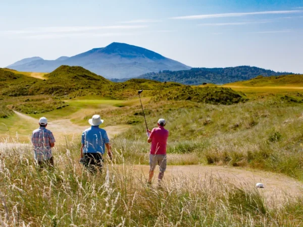 3 golfers playing, mountain view ahead, golfing holiday homes in County Mayo, Ireland.