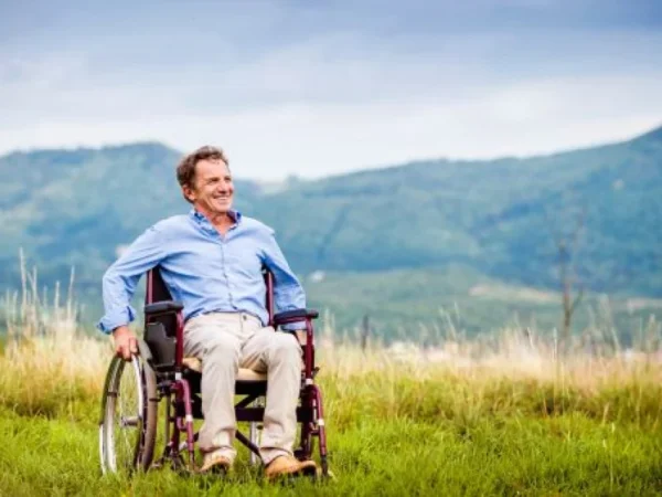 A smiling man on the wheelchair in the field, wheelchair accessible holiday homes in County Roscommon, Ireland.